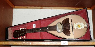 Lot 381 - Cased (a.f.) mandolin, sheet music a tuner and plectrum