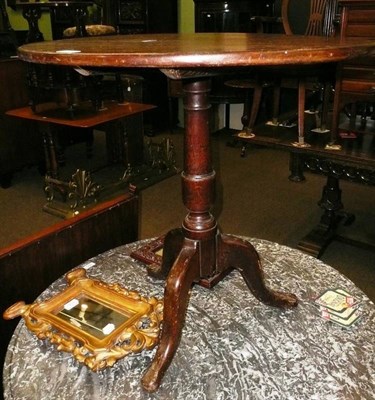 Lot 577 - An oak tripod table with tilt top