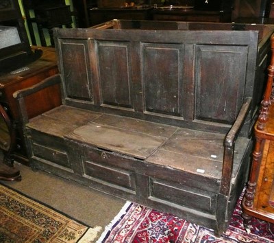 Lot 636 - An 18th century panelled oak settle