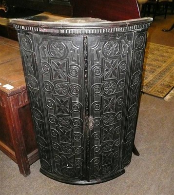 Lot 643 - A bow fronted oak wall hanging corner cabinet with carved decoration