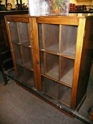 Lot 668 - An oak bookcase with glazed doors