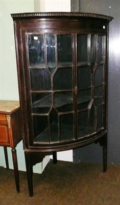 Lot 673 - A Georgian glazed mahogany bow front corner cupboard