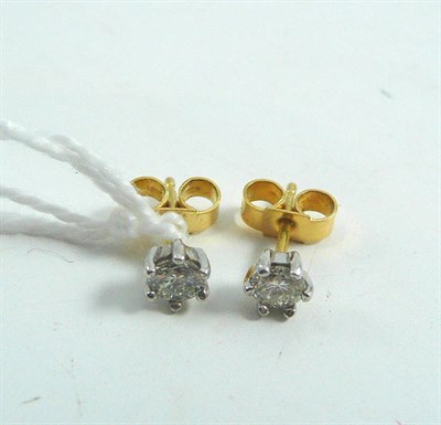 Lot 100 - A pair of diamond solitaire earrings