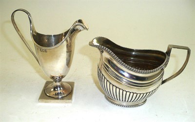 Lot 130 - Georgian silver milk jug and a helmet-shaped cream jug