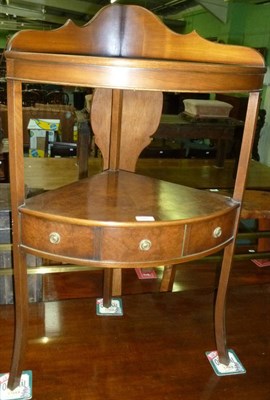 Lot 515 - A reproduction walnut bow front corner washstand