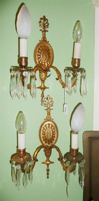 Lot 560 - Pair of gilt brass and glass wall lights with oval backs