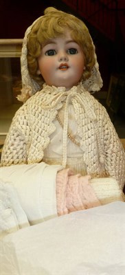 Lot 741 - An early 20th century bisque head doll and a quantity of clothing