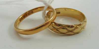 Lot 38 - An 18ct gold patterned band ring and a 22ct gold band ring (2)