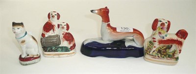 Lot 130 - A porcelain model of a cat, two Staffordshire dogs and a Greyhound inkwell