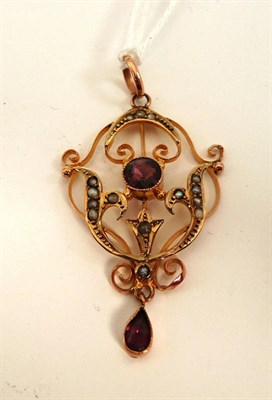 Lot 165 - A garnet and seed pearl pendant, a round cut garnet within a scrolling seed pearl set frame,...