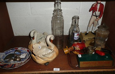 Lot 237 - Three advertising figures, a pharmacy jar, two bottles, a pair of pottery swans, a pearlware...