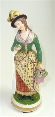 Lot 251 - A Derby porcelain figure of a lady circa 1830, standing holding a basket of flowers (restored)...