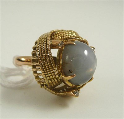 Lot 334 - # A star sapphire and diamond ring, the oval cabochon grey-blue star sapphire with three single-cut