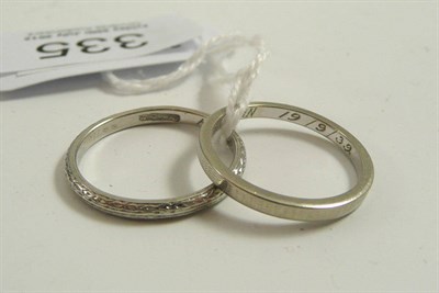 Lot 335 - # A band ring, engraved throughout, finger size O, and an 18ct white gold patterned band ring,...