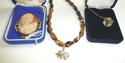 Lot 344 - A cameo brooch, a 'diamond cube' pendant on chain and a tiger's eye necklace