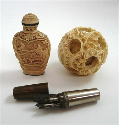 Lot 465 - A carved ivory puzzle ball, a bass and nickel compact nail/manicure kit and a snuff