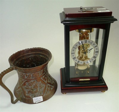 Lot 488 - A modern skeleton clock and an Arts and Crafts copper jug