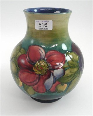 Lot 516 - A Walter Moorcroft Clematis pattern vase, on a blue wash ground, impressed factory marks and...