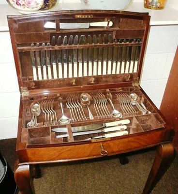 Lot 523 - Canteen of plated cutlery (twelve place setting) in a walnut veneered box on cabriole legs (missing