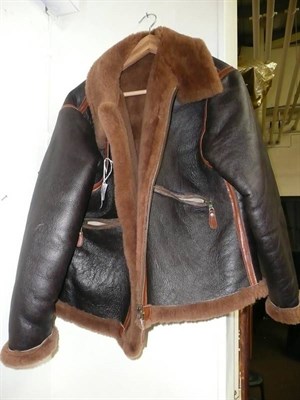 Lot 528 - A brown leather flying jacket, lined with sheepskin, with tan leather over-stitched seams, zip...