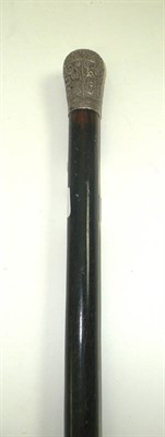 Lot 530 - # A white metal mounted ebonised cane, late 19th century, with foliate scroll and scale decoration