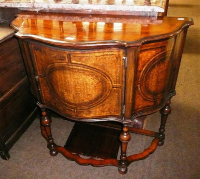 Lot 780 - A figured walnut serpentine cabinet