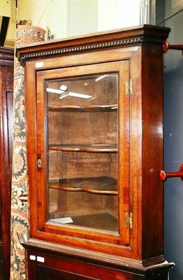 Lot 786 - A Georgian oak corner cupboard with glazed door