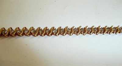 Lot 77 - A diamond set line bracelet, stamped '10k'