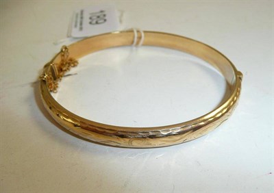 Lot 189 - A 9ct gold half engraved bangle