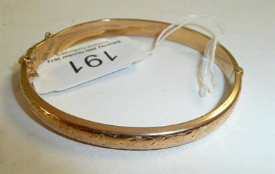 Lot 191 - A 9ct gold half engraved bangle