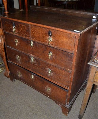 Lot 572 - An 18th century oak straight fronted chest of drawers of two short over three long drawers...