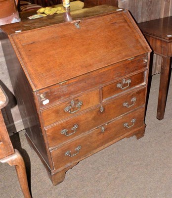 Lot 587 - An 18th century oak bureau of small proportions with hinged lid, over two short and two long...