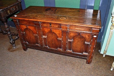 Lot 653 - An oak blanket box with hinged lid of three plank construction above a plain frieze with arched...