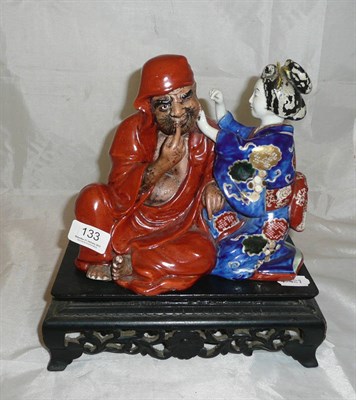 Lot 133 - Japanese porcelain figure group of a bijin and Bodhidharma, circa 1900 with stand