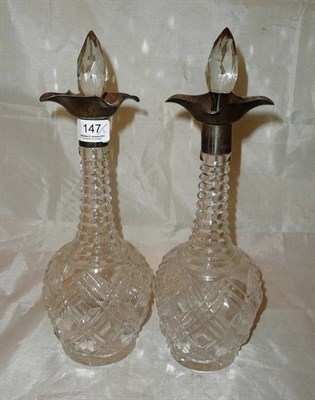 Lot 147 - A pair of heavy cut glass decanters with silver collars