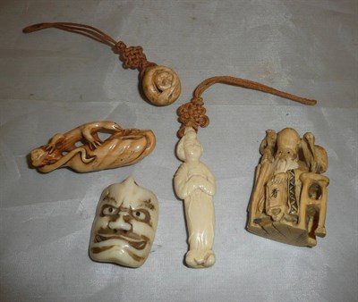 Lot 182 - A carved ivory Noh mask and four netsuke; a woman, a lizard on a log, an elder and a frog,...