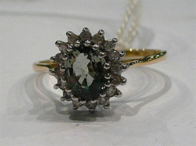 Lot 198 - An 18ct gold green sapphire and diamond cluster ring, the oval mixed cut green sapphire within...