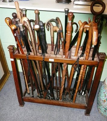 Lot 231 - An oak stick stand and collection of thirty five various walking sticks and canes