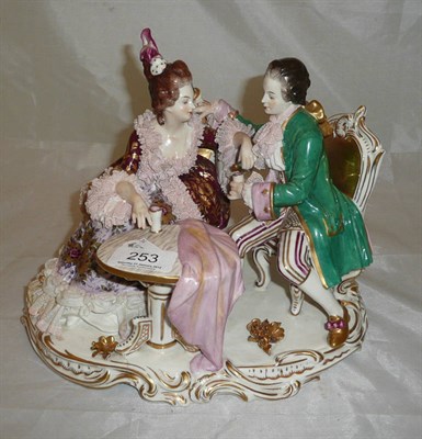 Lot 253 - A German porcelain figure group of a lady and gentleman seated at a tea table
