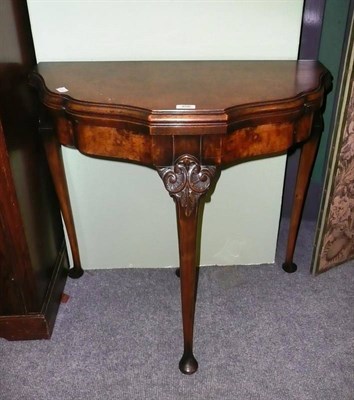 Lot 466 - A walnut shaped demi-lune fold-over card table