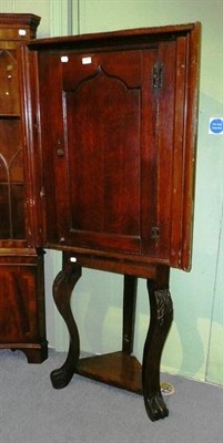 Lot 589 - * An oak corner cupboard on associated stand