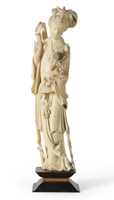 Lot 81 - A Chinese Ivory Figure of a Maiden, late Qing Dynasty, standing, her hair up, wearing flowing...