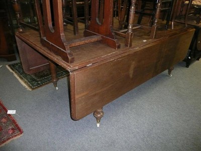 Lot 643 - A large oak drop-leaf dining table