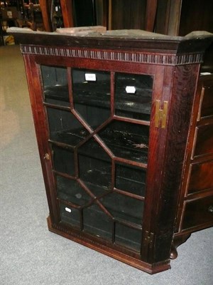 Lot 646 - A glazed oak hanging corner cupboard