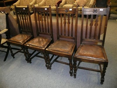 Lot 710 - A set of four early 20th century oak dining chairs with barley twist legs and tulip motif