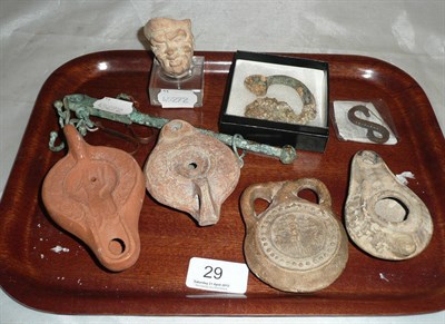 Lot 29 - A bronze slave token, a terracotta mask, three oil lamps, vessel, serpent token and scale