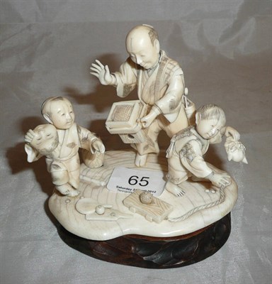 Lot 65 - A Japanese ivory group and wood stand