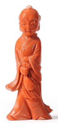 Lot 112 - A Chinese Coral Figure of a Boy, 20th century, standing in flowing robes holding a bag, 10.5cm high