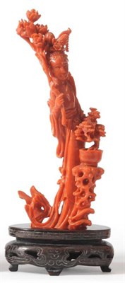Lot 115 - A Chinese Coral Figure of a Maiden, standing wearing flowing robes holding a flowering branch,...