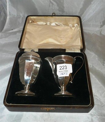 Lot 223 - A cased silver sugar sifter and jug